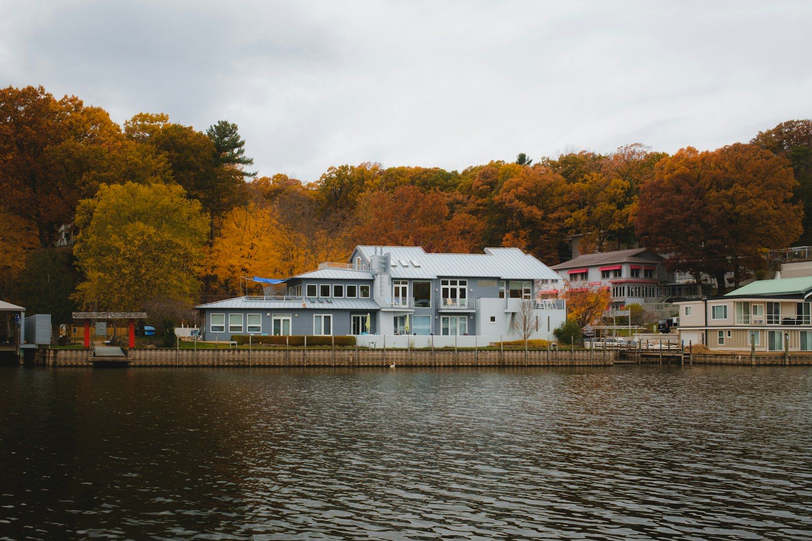 Lakefront homes beneath autumn woods on a Michigan shoreline